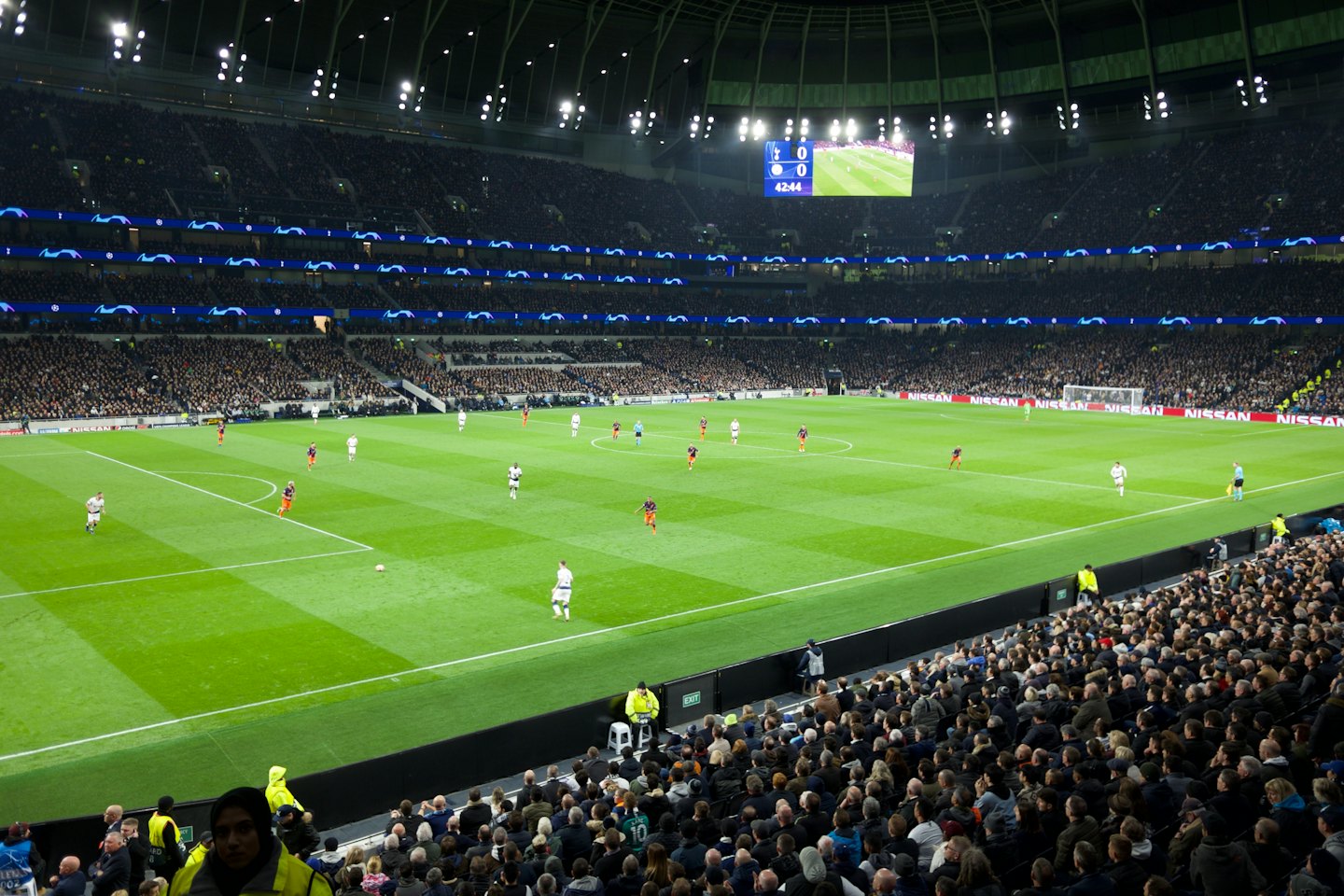 Giocatori in una partita di calcio in uno stadio coperto.
