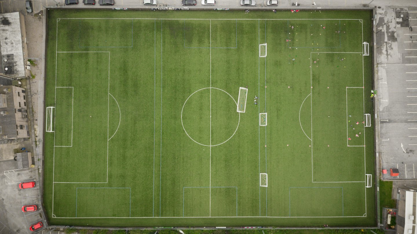 Vista aerea di un campo da calcio con linee bianche e porte da allenamento.